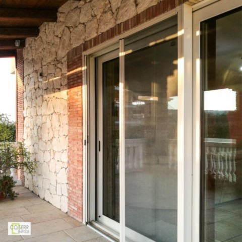 Porta finestra alzante scorrevole color avorio con zanzariera installata in villa ad Augusta