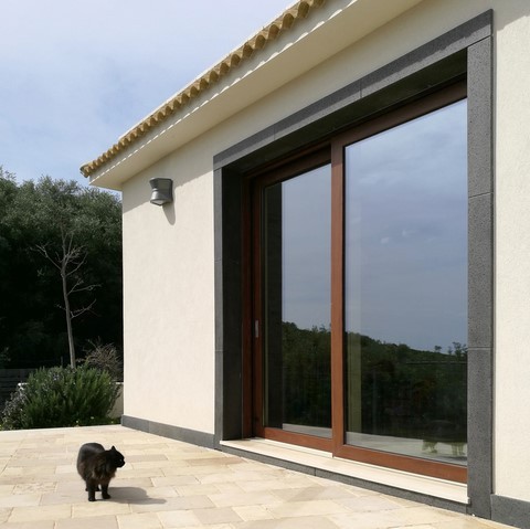 Porta finestra alzante scorrevole in alluminio effetto legno con gatto che si specchia sul vetro ad augusta