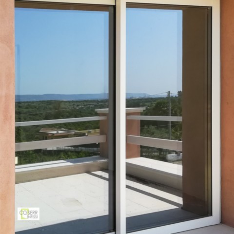 Porta scorrevole a due ante in alluminio avorio installata ad Augusta